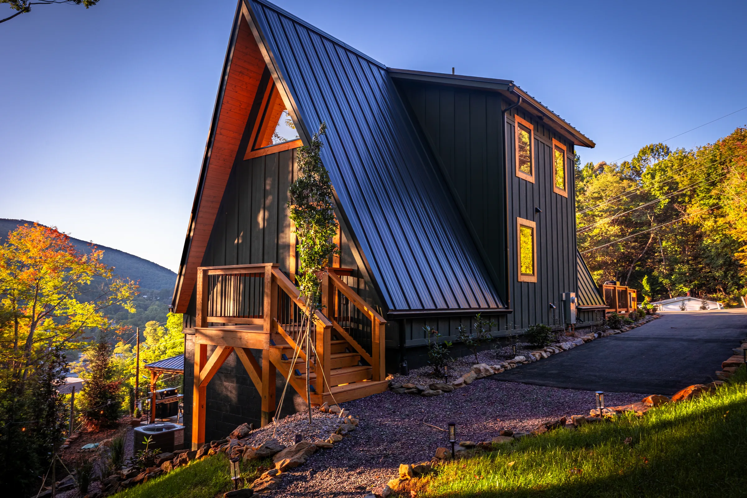 A High Peak A-frame with orange fall trees behind it in West Jefferson, NC.