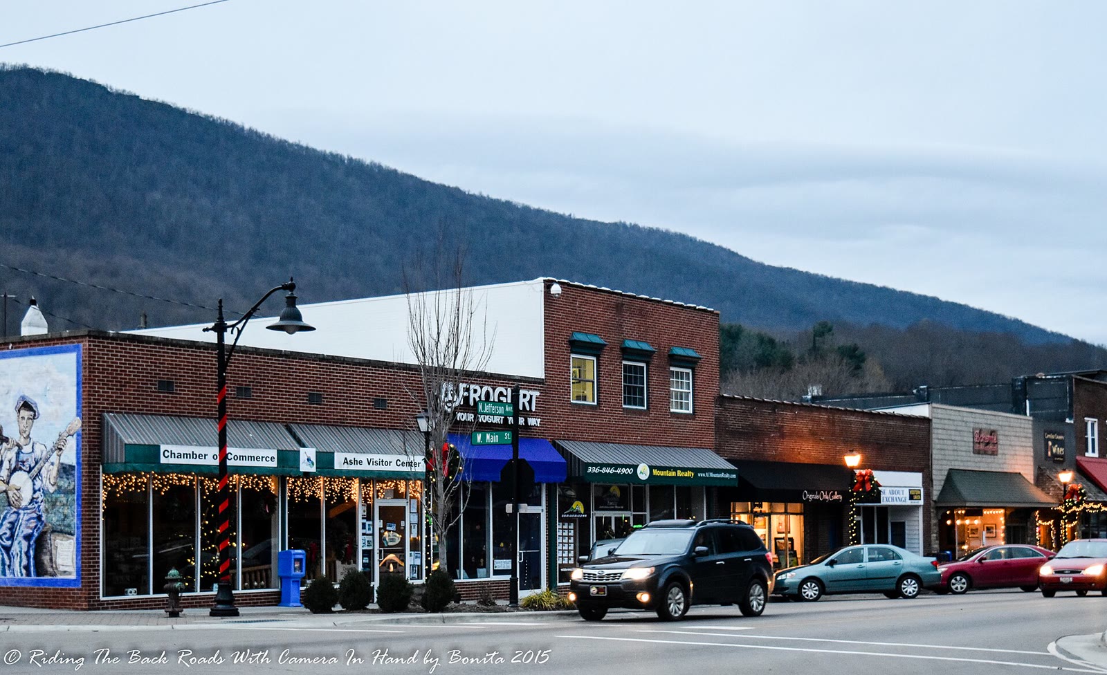 Downtown West Jefferson, a street of brick storefronts with mountains behind the town