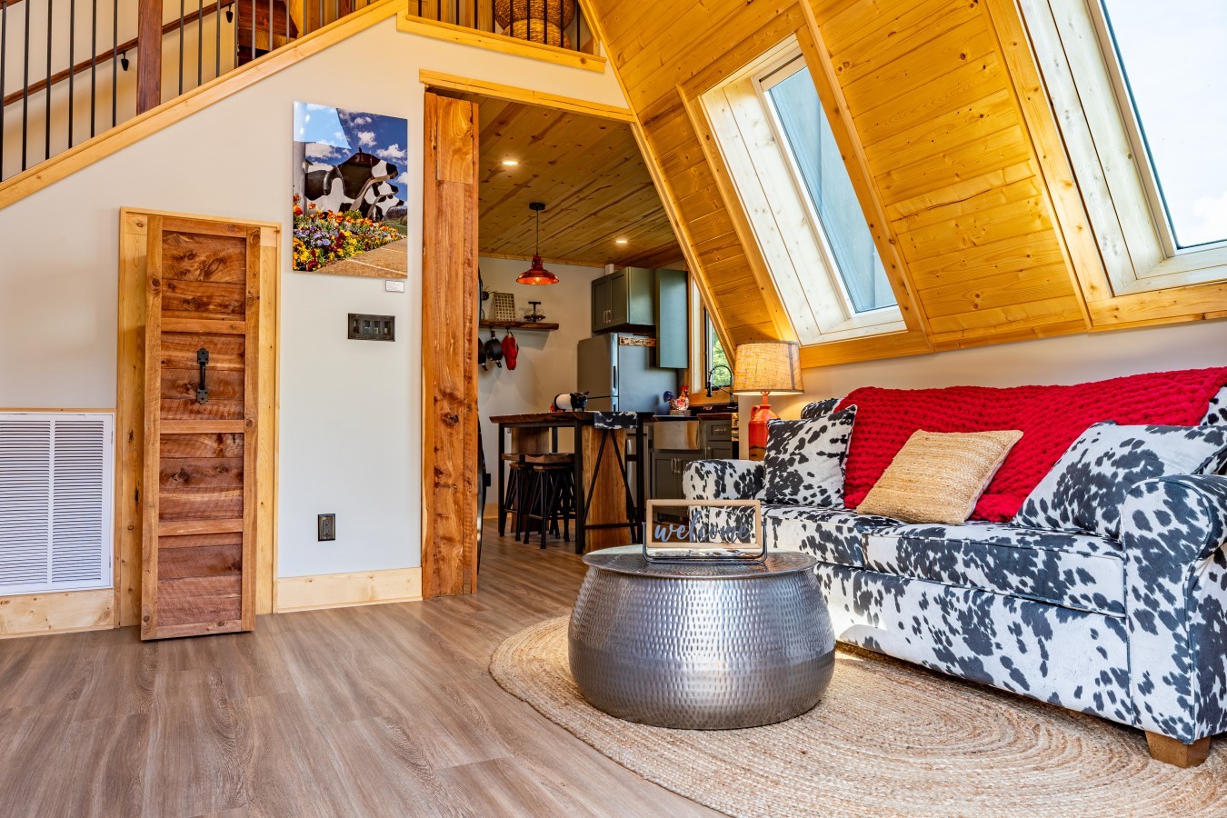 Living room with cow-print sofa and kitchen beyond