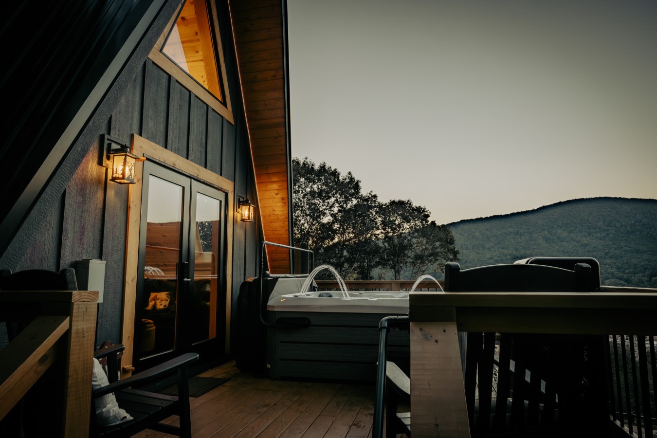 Deck with hot tub and seating at dusk