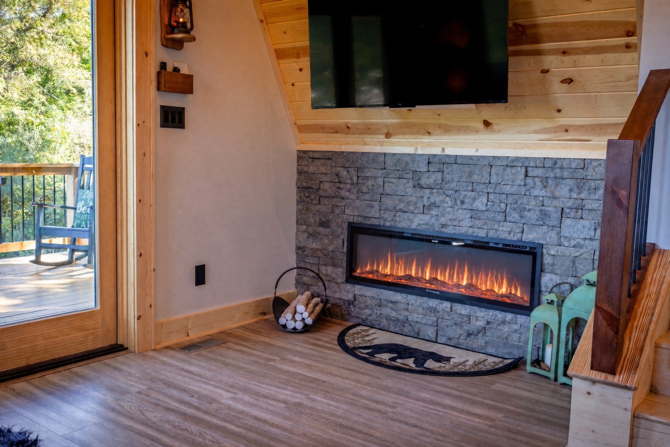 Living room with stone electric fireplace and TV