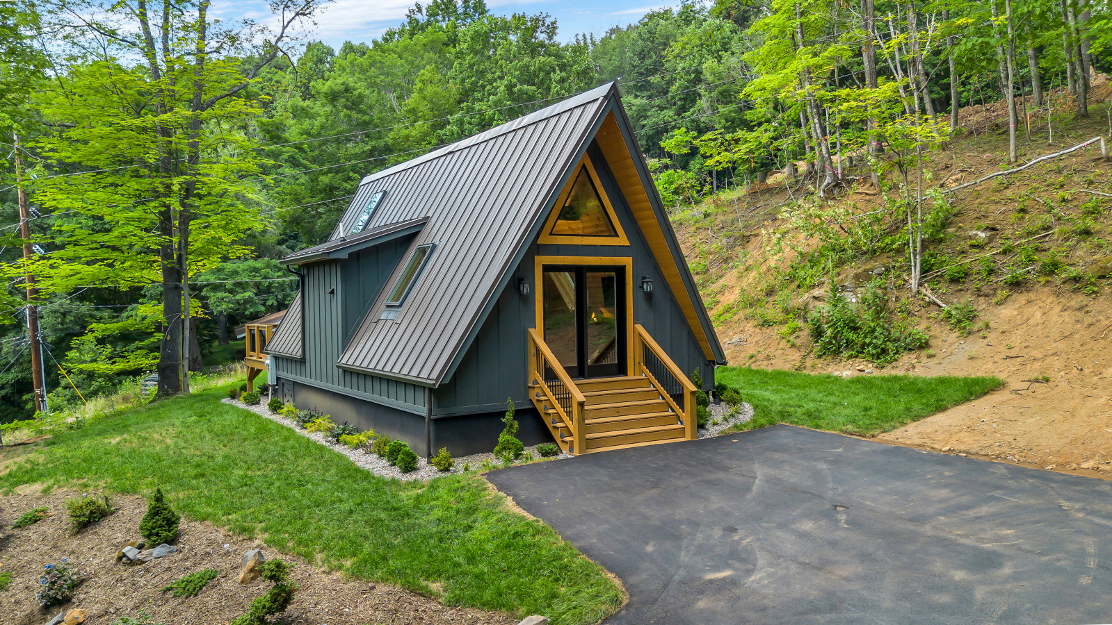 A-frame cabin with a covered deck and string lights
