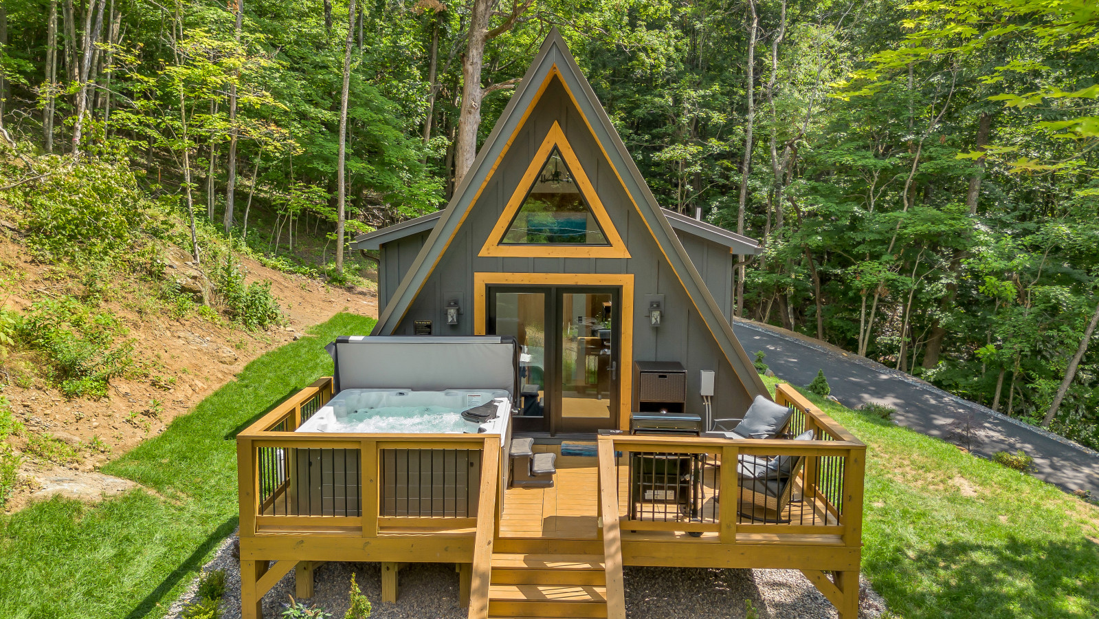 Hot tub on the deck with chairs and a valley view