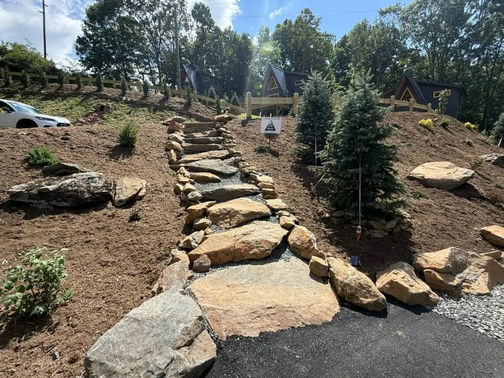 Stone path up a landscaped slope toward High Peak A-frame cabins in West Jefferson, NC